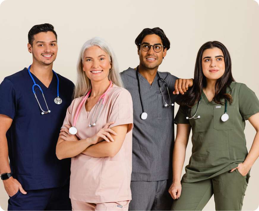 A healthcare professional in blue scrubs uses a smartphone