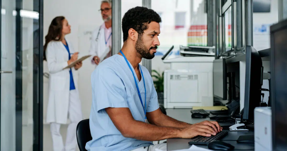Nurse writing up nursing report at shift end