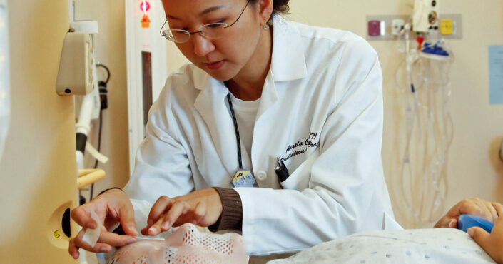 Radiation therapist marking face mask for radiation therapy
