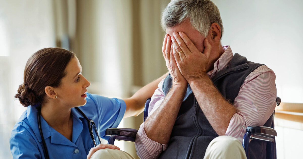 Nurse taking care of sad senior man