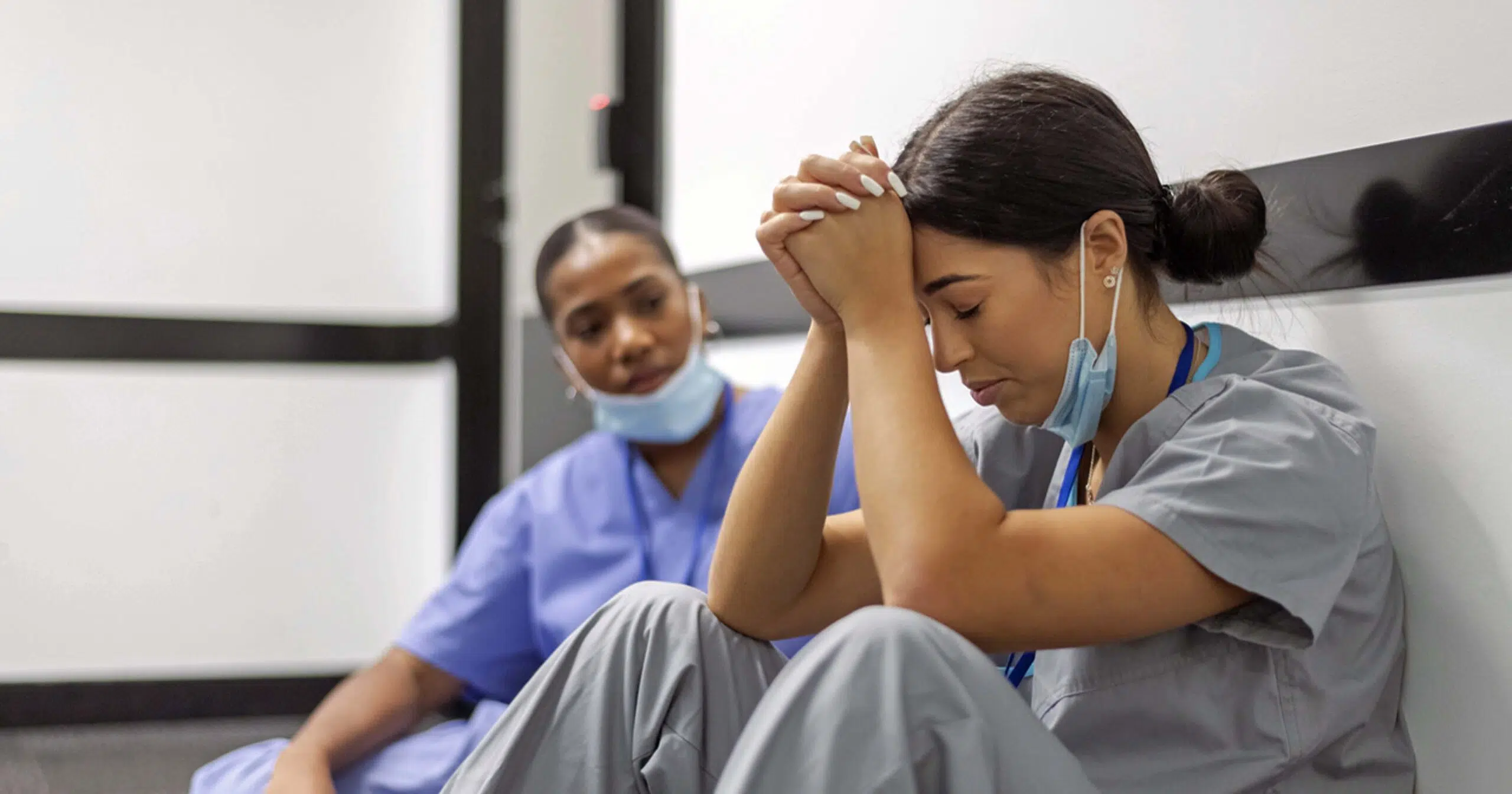 Distressed nurse being supported by co-worker