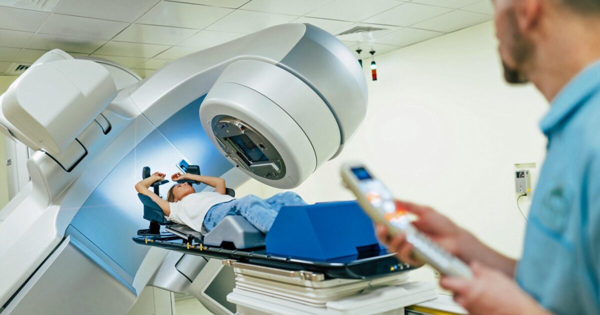 Cancer patient receiving radiation therapy from radiation therapist