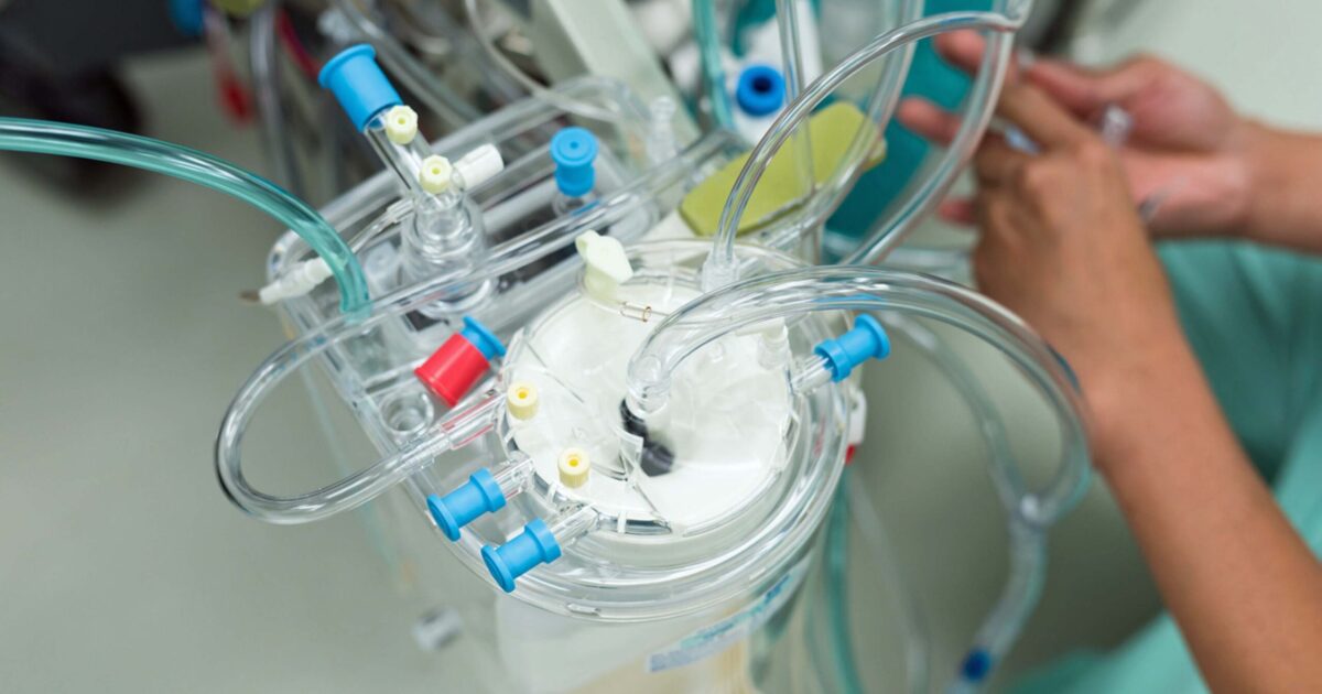 Perfusionist prepares heart lung bypass machine for surgery