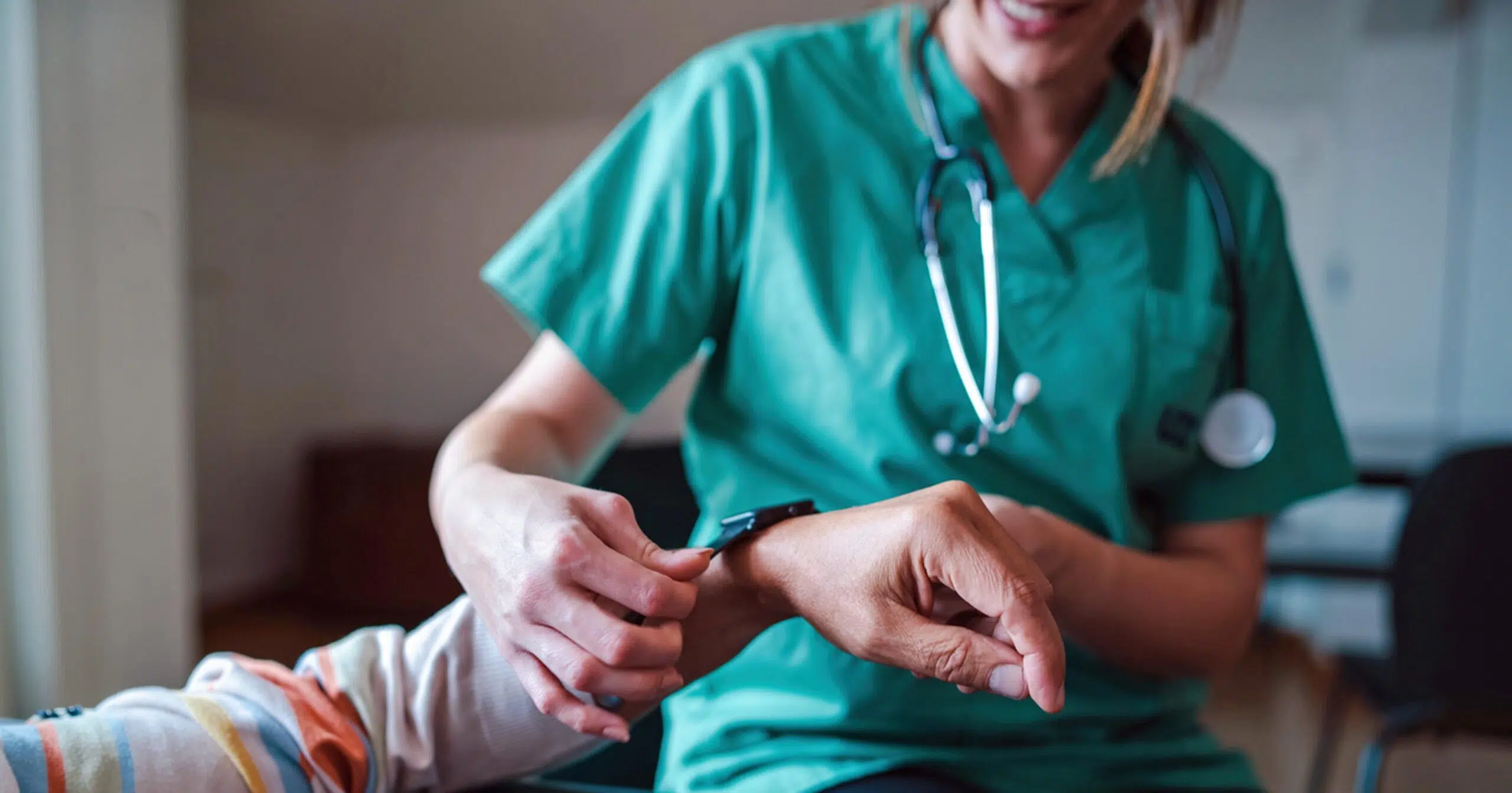 Nurse putting wearable health monitor on a patient